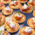 Mini blini topped with smoked salmon, crème fraîche, and fresh chives