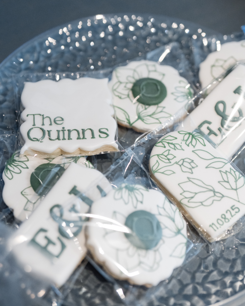 Custom wedding cookies featuring "The Quinns" monogram and botanical designs with wedding date