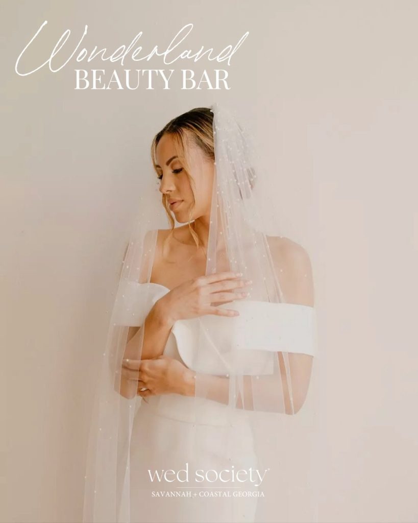 Bride in modern strapless gown with flowing veil and elegant updo hairstyle