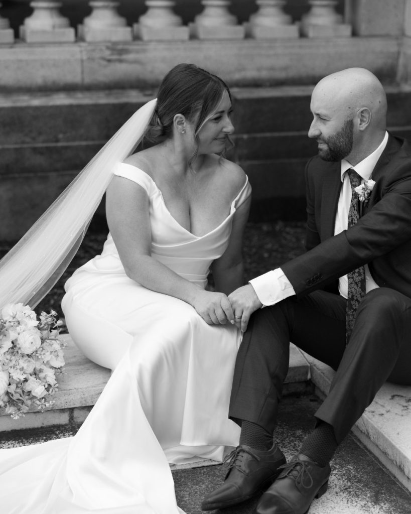 Katy and Steve share an intimate moment seated on stone steps at their botanical garden wedding