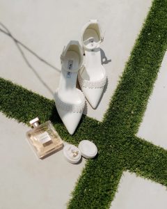 bridal heels, perfume and jewelry close up photo on grass at Chateau 1800