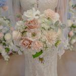 Soft pink and white bridal bouquet featuring roses, dahlias, ranunculus, and eucalyptus greenery