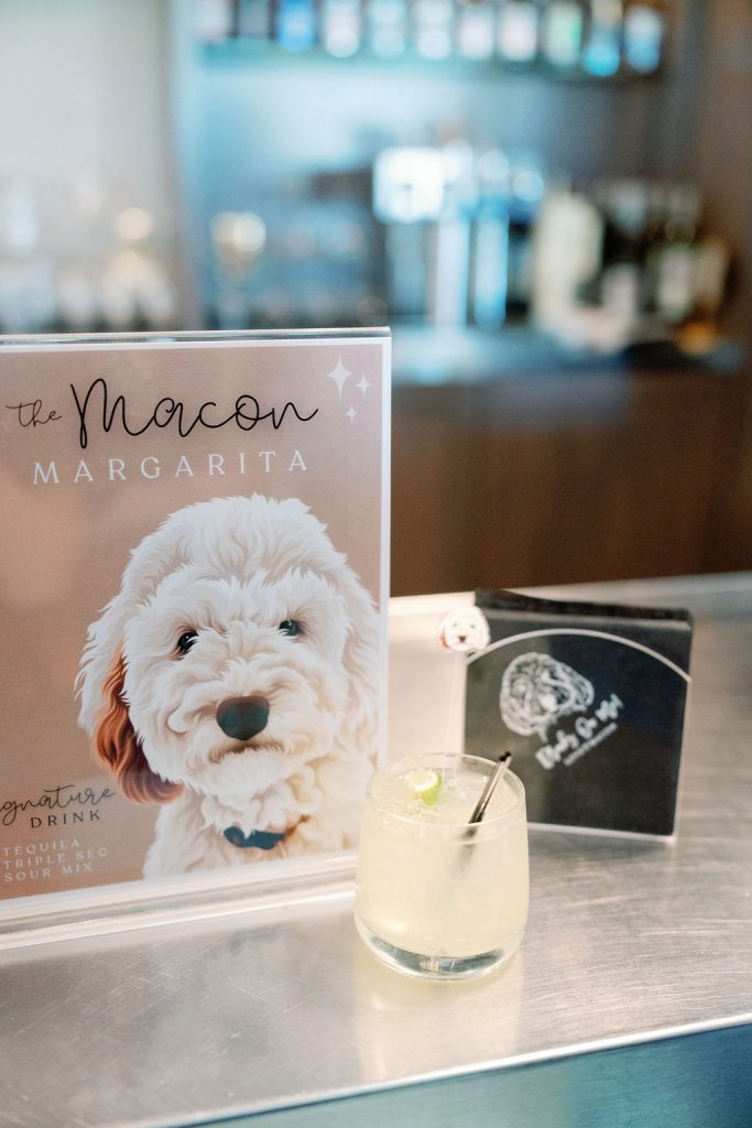 Custom cocktail menu featuring the couple's dog Macon beside a margarita at the bar