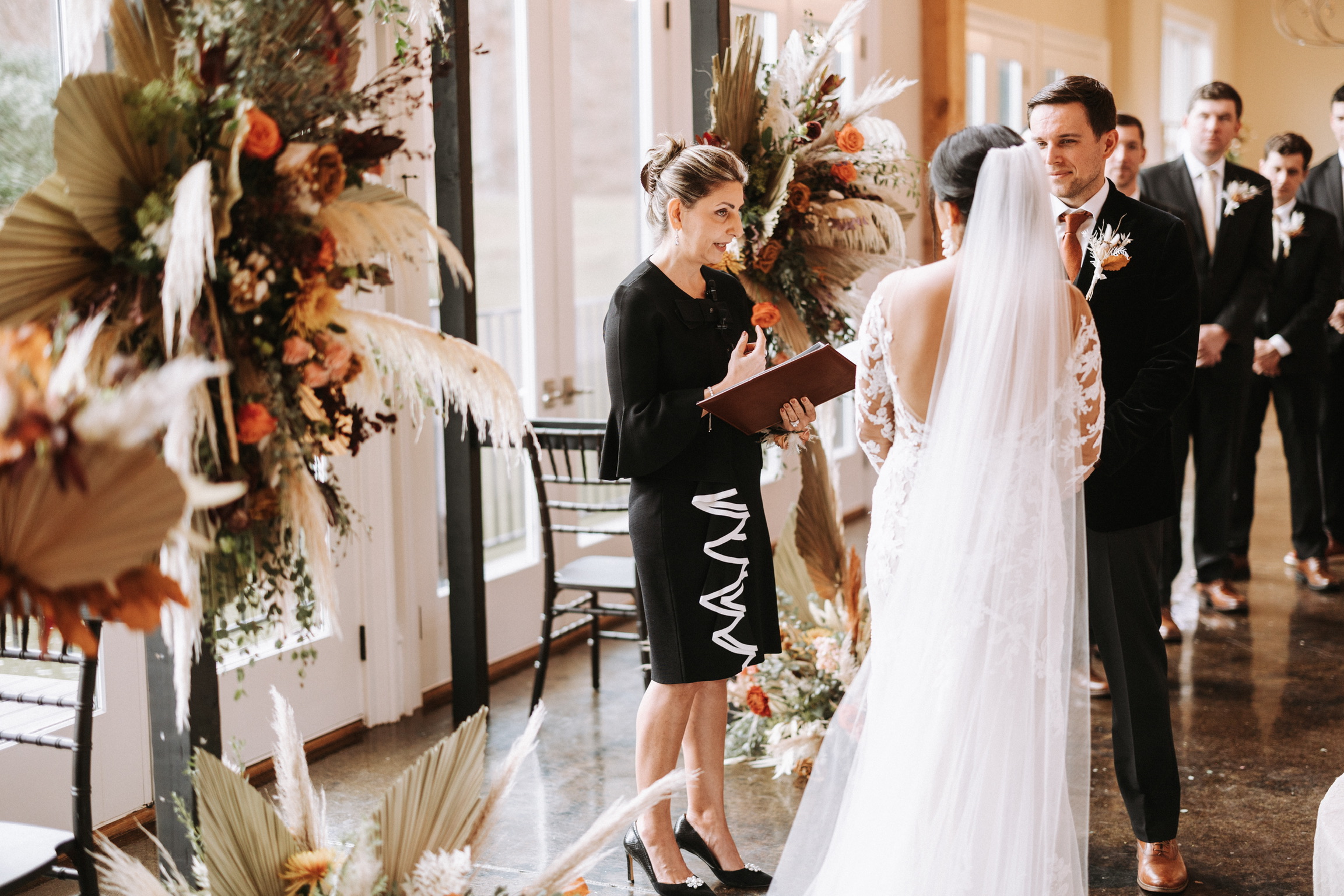 Bride in white gown during Persian wedding ceremony with bridesmaids and officiant