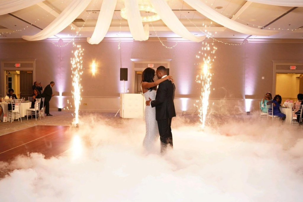 Bride and groom sharing first dance surrounded by sparkler fountains and romantic fog effects at Alpharetta wedding