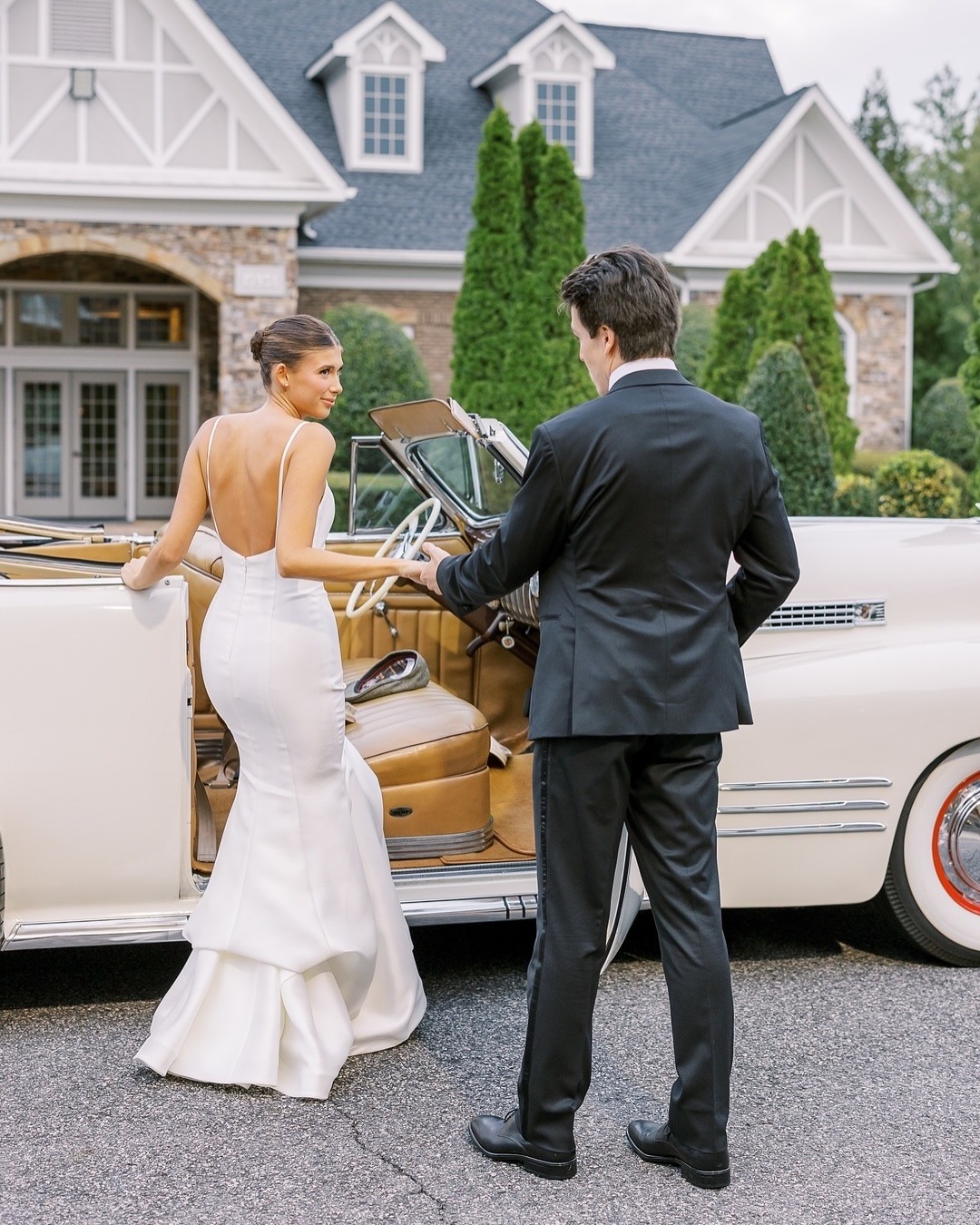 Bride and groom walking toward vintage car