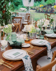 Elegant outdoor wedding table with wood chairs, white beaded-rim plates, and fresh floral centerpieces