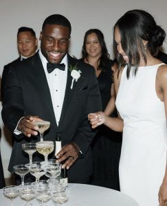 Couple celebrating with champagne tower at elegant black-tie wedding reception