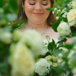 Bride holding white rose bouquet with soft smile, showcasing wedding videography by Ben Schnell Productions