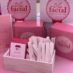 The Only Facial branded pink boxes and business cards displayed with beauty tools in wooden organizer