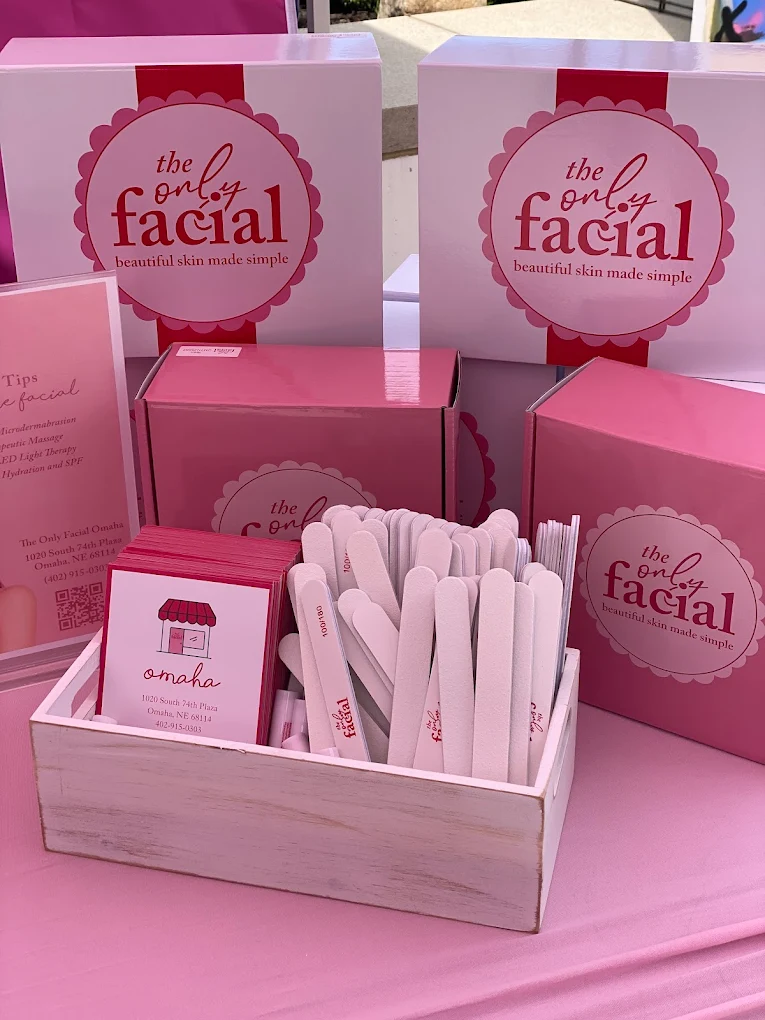 The Only Facial branded pink boxes and business cards displayed with beauty tools in wooden organizer