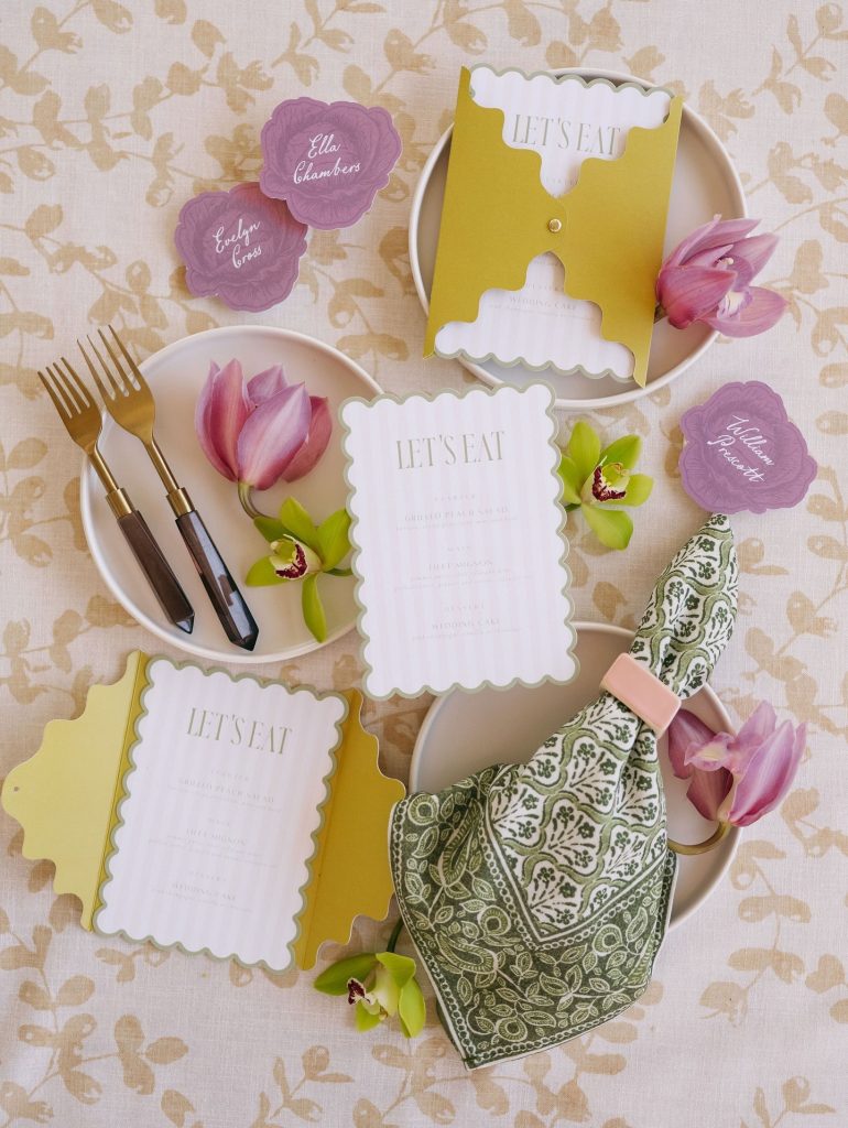 Elegant wedding table setting with Nebraska-shaped menu cards in chartreuse, scalloped place cards in lavender, and tulips with gold flatware