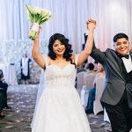 Newlyweds celebrating with raised hands after their wedding ceremony
