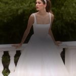 Bride in minimalist square-neck ballgown with flowing tulle skirt against garden backdrop