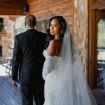 Bride and groom walking together at rustic venue with brick walls and exposed beams