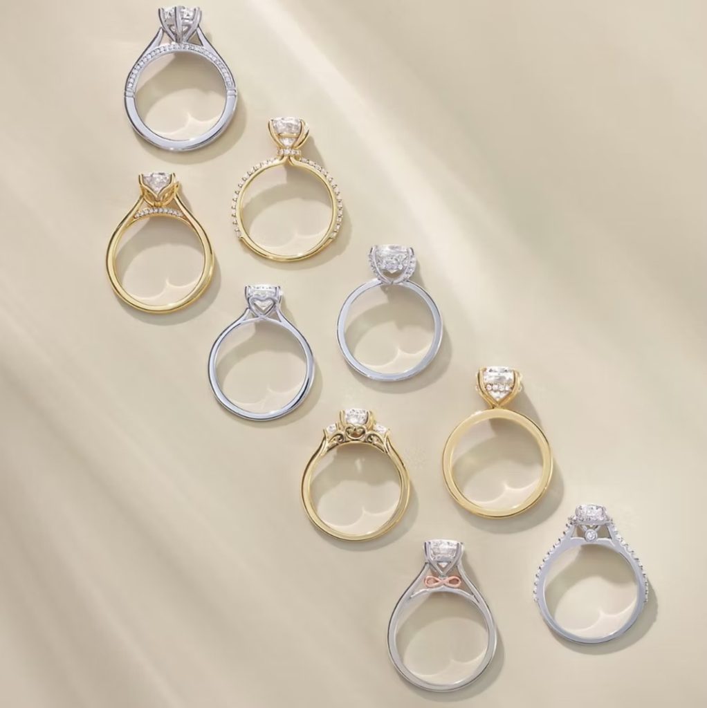 Collection of diamond solitaire engagement rings in gold and white gold settings displayed on neutral background