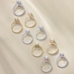 Collection of diamond solitaire engagement rings in gold and white gold settings displayed on neutral background