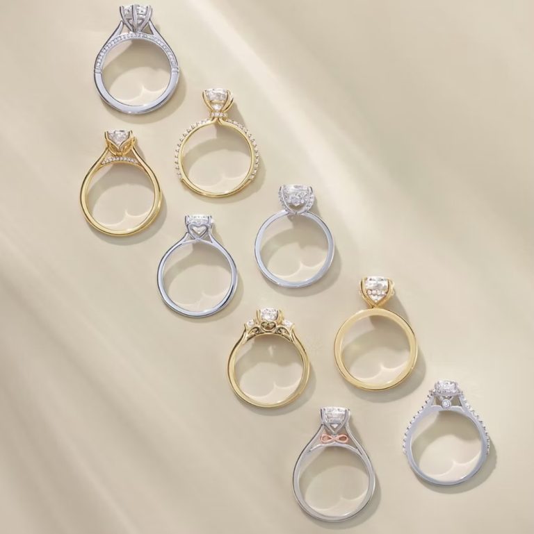 Collection of diamond solitaire engagement rings in gold and white gold settings displayed on neutral background