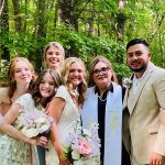 Reverend Susie with wedding party and newlyweds in outdoor garden setting