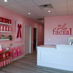 The Only Facial Omaha reception area with pink branding, retail shelves, and white front desk