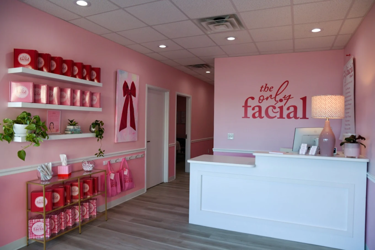 The Only Facial Omaha reception area with pink branding, retail shelves, and white front desk