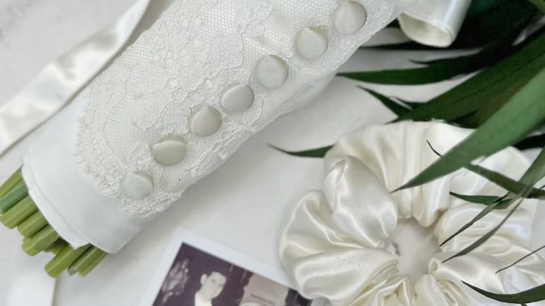 White fabric with embroidered buttons beside vintage photo and silk fabric detail