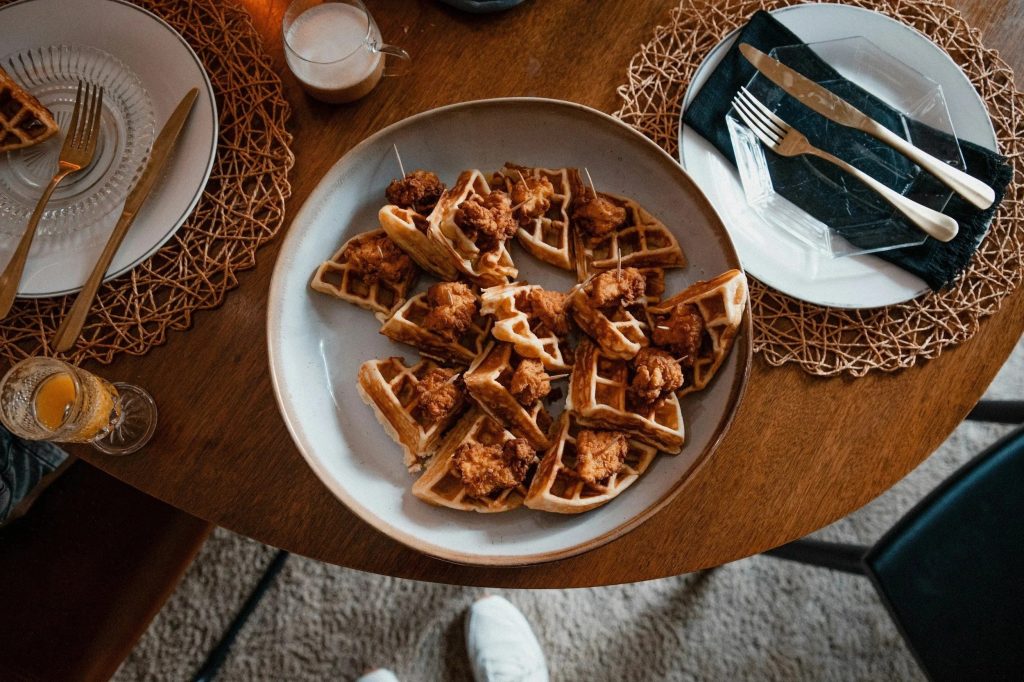 Close-up of chicken and waffles served on white ceramic plate