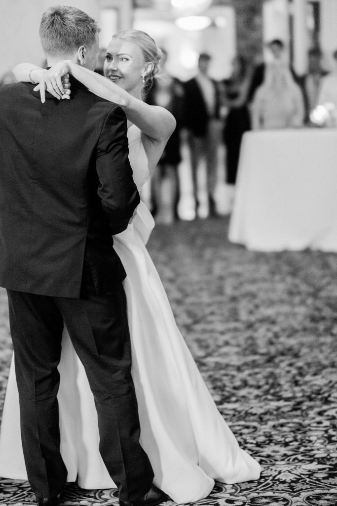 Bride Catherine and groom Zach sharing first dance on patterned carpet in elegant ballroom