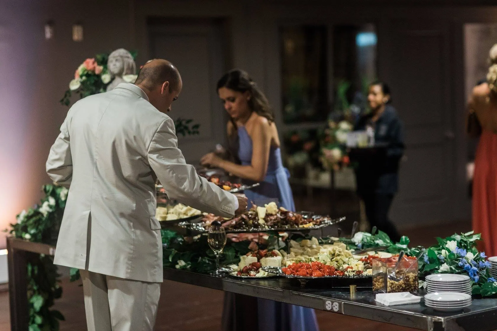 Wedding guests being served at buffet table with elaborate food display