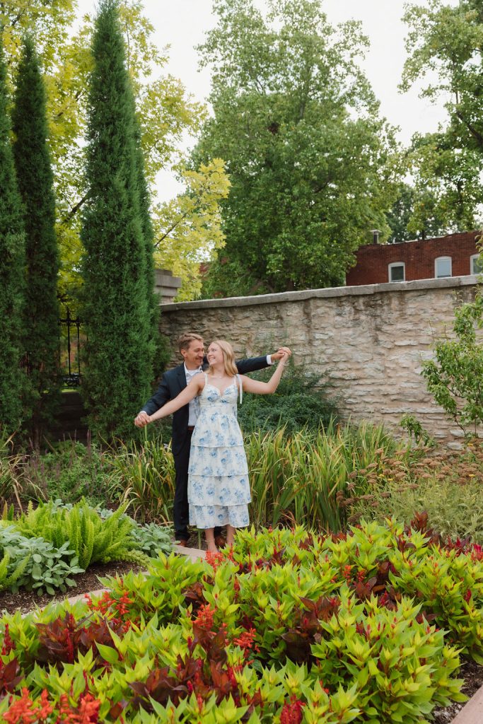 Engaged couple standing in lush greenery at Missouri Botanical Gardens. Captured by Mad Land Photography