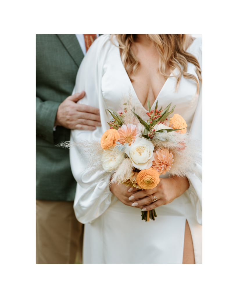 A close-up of the bride’s bouquet featuring soft peach, ivory, and blush flowers with delicate greenery.
