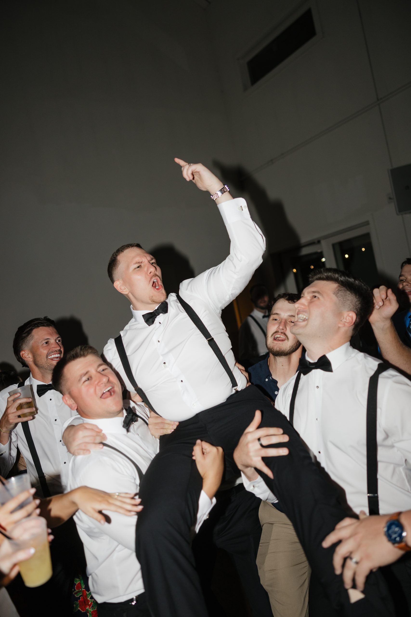 Groom being lifted into air during reception.