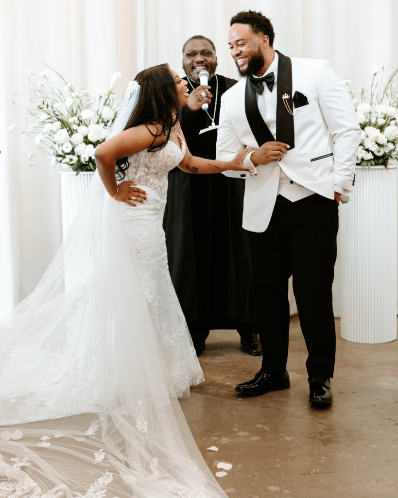 Bride and groom celebrating during their wedding ceremony at The Casey in Charlotte surrounded by white florals