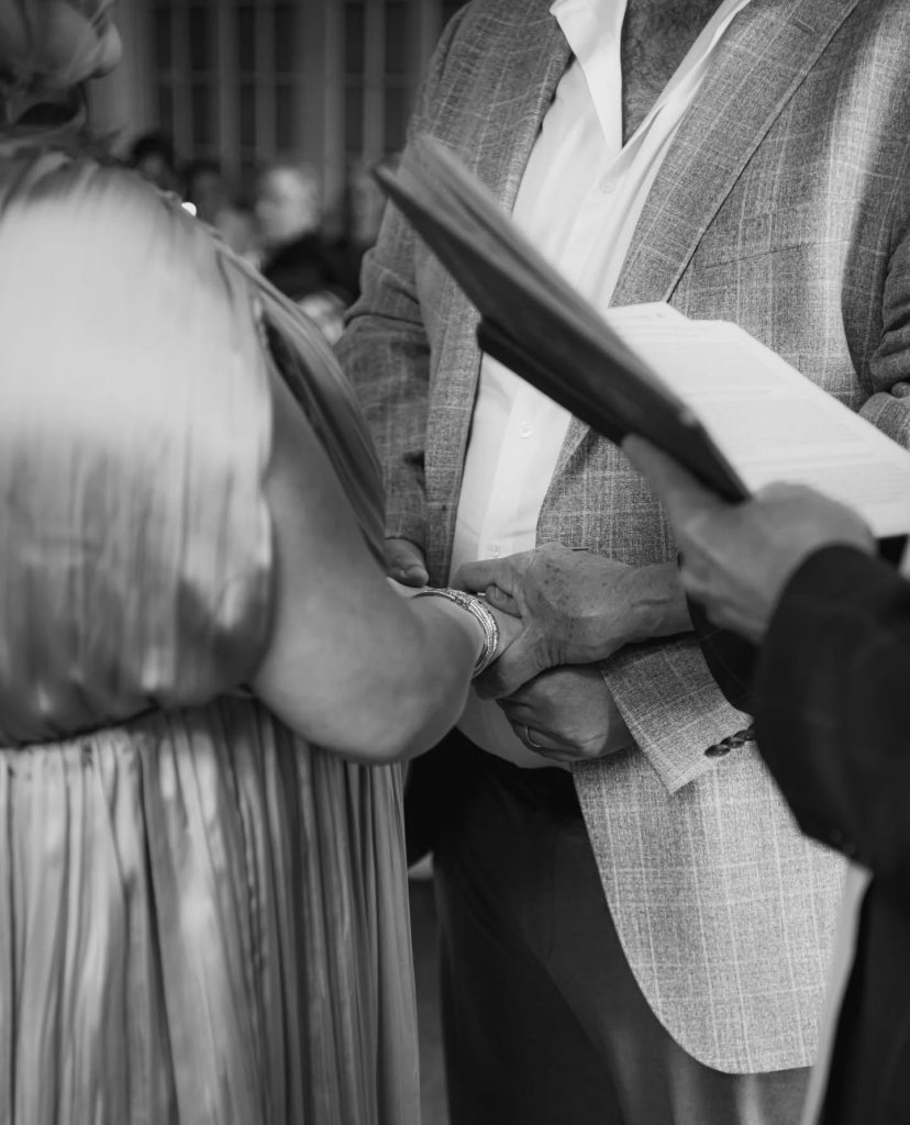 black and white close up image for couple holding hands during wedding ceremony
