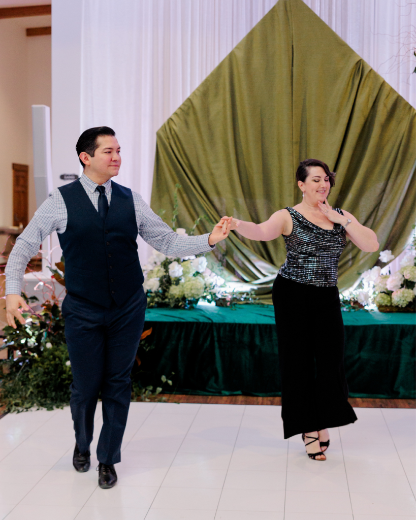 Dancers Amy and Jesse of Hearts in Rhythm performing in front of green draped backdrop and floral stage design at King Cole Farm in Dover, Delaware.