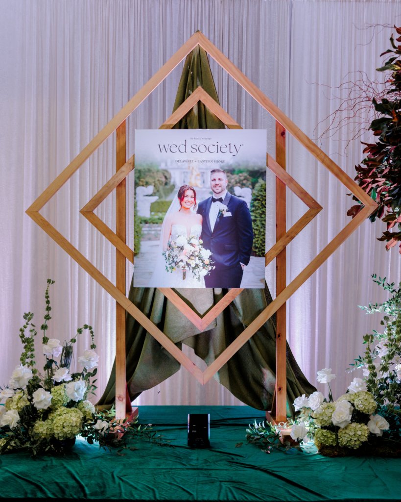 Wed Society Book of Weddings magazine displayed within geometric wooden frame with floral styling by J. Starr’s Flower Barn at King Cole Farm in Dover, Delaware.