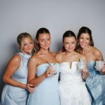 Bride and Bridesmaids in photo booth with crisp white background provided by Glow Booth STL.