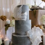 Three tier grey marbled wedding cake with white accents