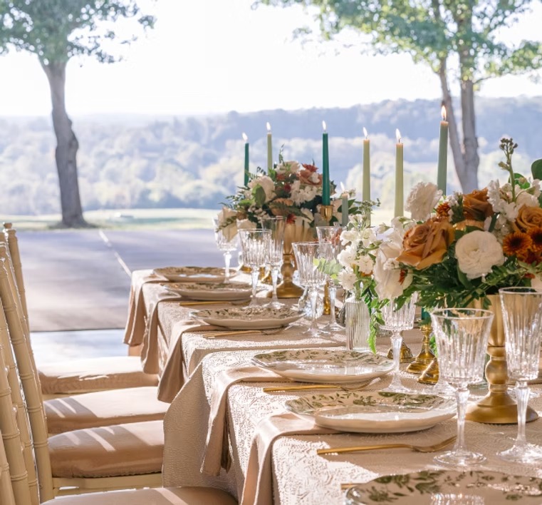 Long Rectangular reception table with gold decor accents and lush flower vases