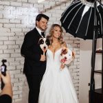 Couple holding props in a photo booth created by Glow Booth STL