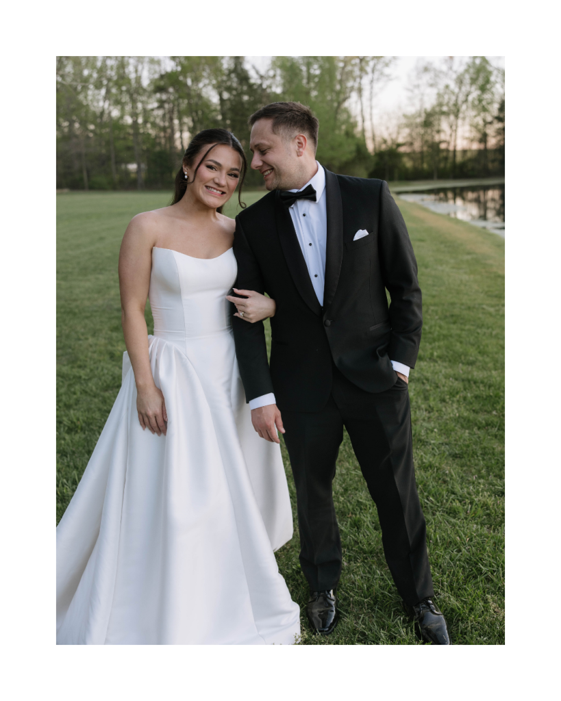 Bride and groom standing together on the lawn, smiling in classic wedding attire