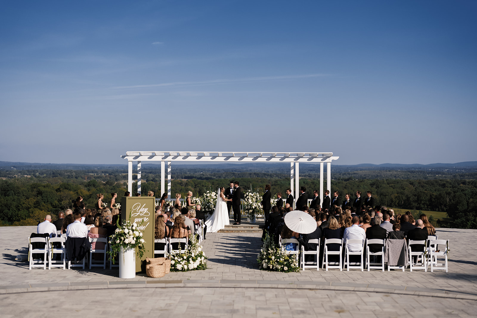 Outdoor ceremony space with large white pergola overlooking scenic mountains