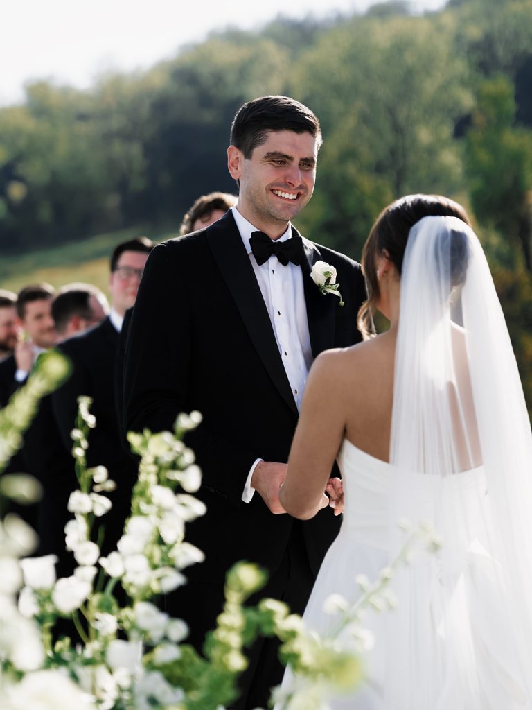 Groom looking at bride lovingly during wedding ceremony