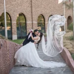 bride and groom dip kiss with veil in air