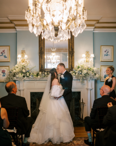 Indoor wedding ceremony at The Morehead Inn Charlotte with chandelier and fireplace backdrop Wed Society Charlotte feature
