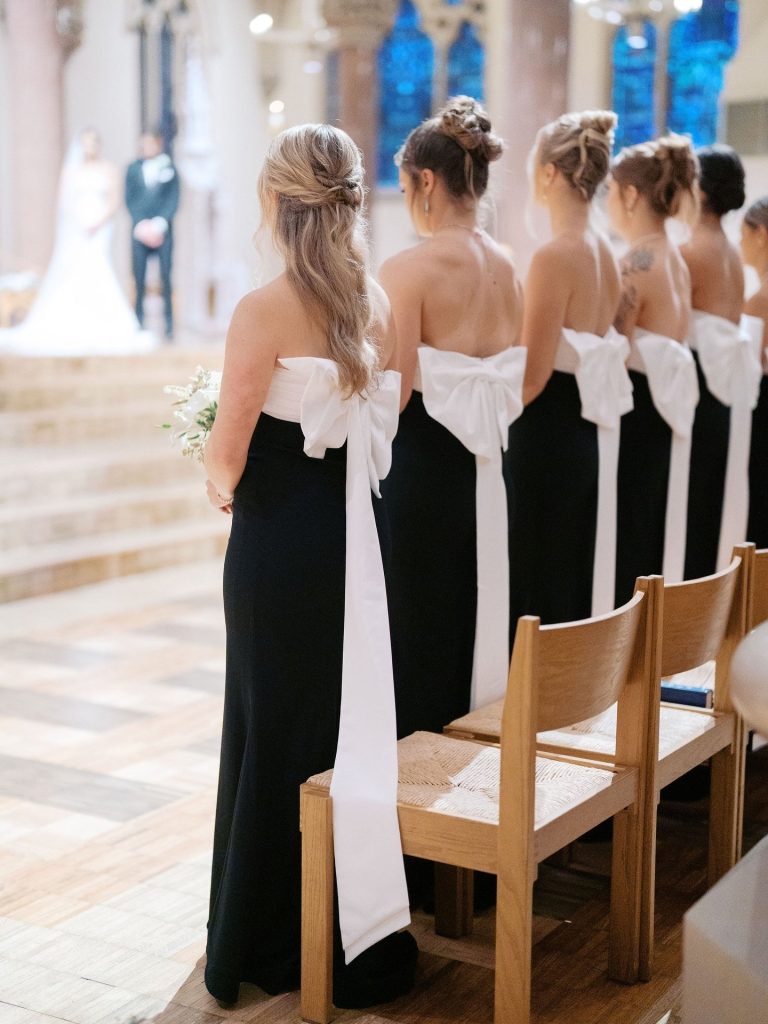 Black bridesmaid dress with big white bows on the back.
