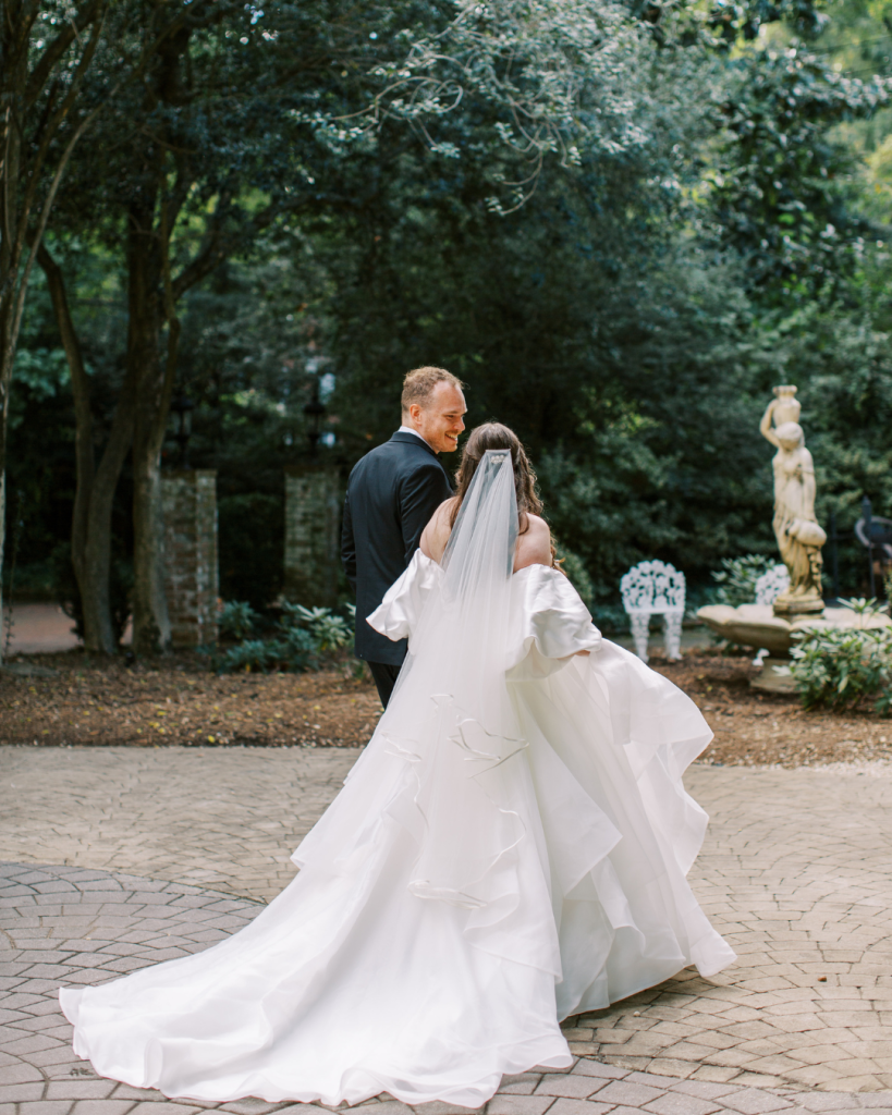 Bride and groom walking outdoors on garden path at The Morehead Inn Charlotte romantic wedding portraits