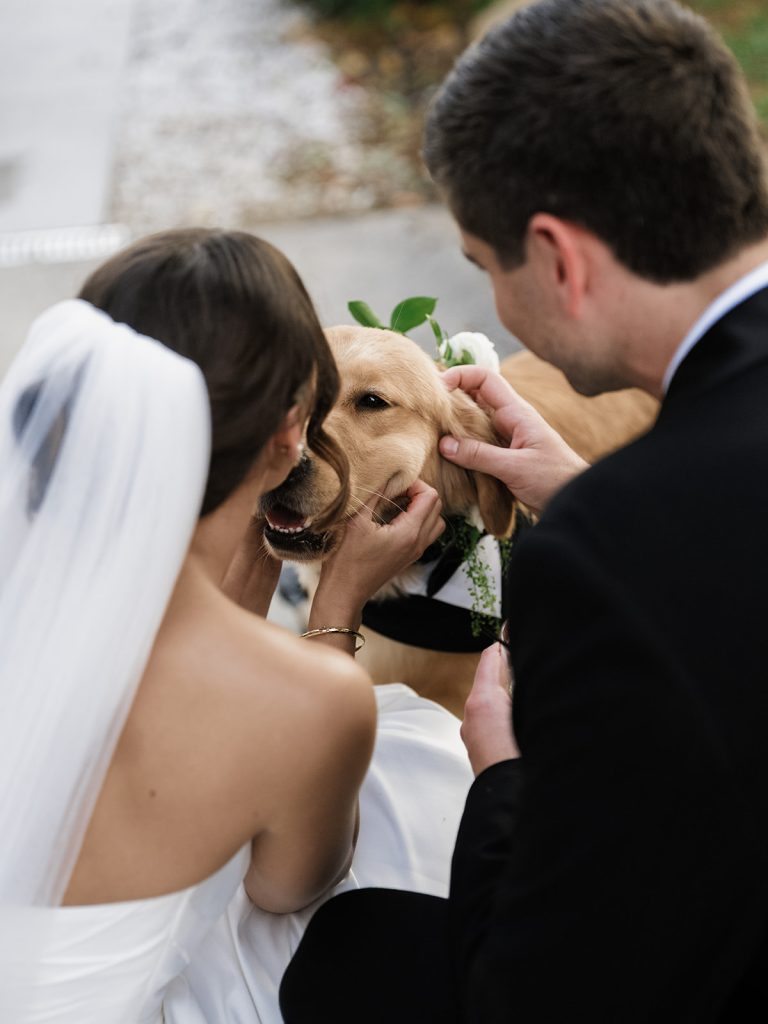 Bride and Groom petting their dog after wedding ceremony