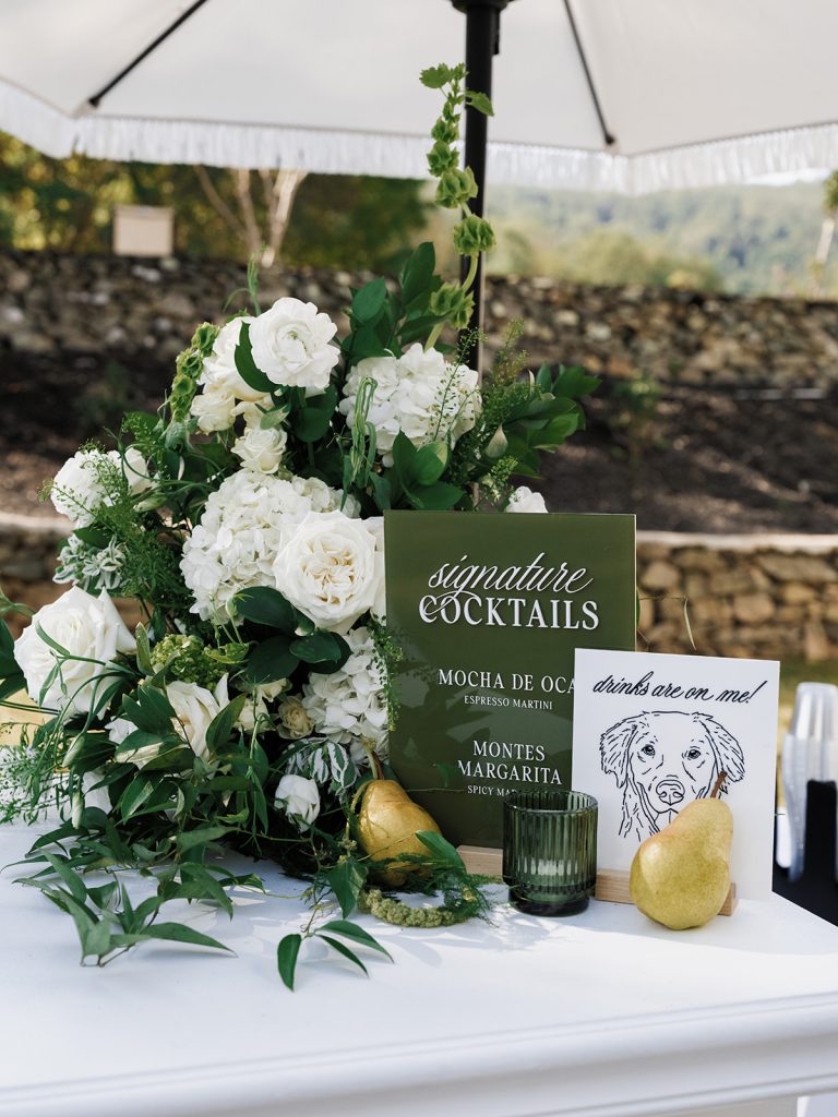 Detailed view of signature cocktail sign with dog photo and florals around