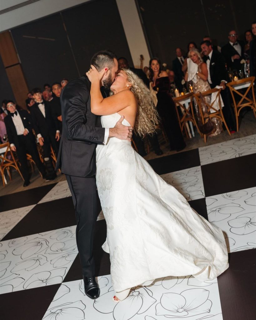 A groom dipping his bride on the custom checkered dance floor by Exclusive Events, Inc.